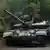 Two Ukrainian soldiers ride a tank in June 