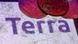 The TerraUSD logo apprearing on a cracked screen with prop Bitcoins The TerraUSD logo apprearing on a cracked screen with prop Bitcoins
