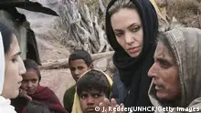 ARCHIV 2005 JABEL SHAROON, PAKISTAN - NOVEMBER 26: In this handout photo supplied by the United Nations High Commission for Refugees (UNHCR), UNHCR Goodwill Ambassador Angelina Jolie listens as a local woman in this village 6,000 feet above sea level in Pakistan-administered Kashmir, tells a UNHCR worker about her preparations for the coming winter, which includes salvaging materials from the remains of houses after the earthquake, November 26, 2005 in Jabel Sharoon, Pakistan. (Photo by J Redden/UNHCR via Getty Images)