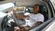 A woman sits behind the steering wheel of a car. A woman sits behind the steering wheel of a car.