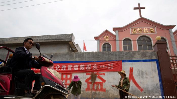 A banner reading 'Educate the believers with excellent Chinese traditional culture' outside a church
