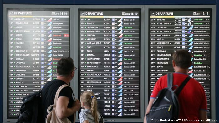 People look at a flight information display at the Vnukovo International Airport in Moscow (Vladimir Gerdo/TASS/dpa/picture alliance)