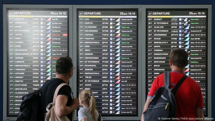 People look at a flight information display at the Vnukovo International Airport in Moscow (Vladimir Gerdo/TASS/dpa/picture alliance)