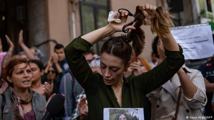 Esta mujer iraní que vive en Turquía se corta el cabello frente al consulado iraní en Estambul como protesta por la muerte de Mahsa Amini, de 22 años, quien falleció a causa de un infarto y un coma que sufrió en una comisaria de Teherán, donde estaba detenida por la llamada policía moral por no llevar bien el velo, prenda obligatoria en el país.