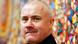 Portrait von Damien Hirts vor buntem Hintergrund. Portrait von Damien Hirts vor buntem Hintergrund.