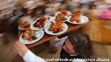 Ein Kellner trägt auf dem Oktoberfest Hendl (Hähnchen) auf einem Tablett durch ein Bierzelt. (zu dpa: Vegane Weißwurst und Seitangulasch: Fleischlos auf der Wiesn) +++ dpa-Bildfunk +++