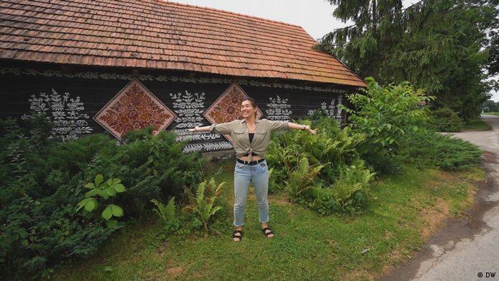 Die polnische Vloggerin Eva zu Beck vor einem dekorierten Holzhaus in Polen