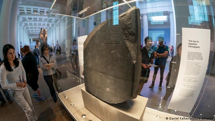 The Rosetta Stone behind glass, with viewers on all sides.