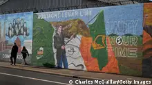 BELFAST, NORTHERN IRELAND - SEPTEMBER 22: People walk past a mural calling for Irish unity on the day that the Northern Ireland census was released on September 22, 2022 in Belfast, Northern Ireland. The latest census figures show that for the first time in Northern Irelands 101-year history there are more people from a Catholic background in Northern Ireland than Protestant. The proportion of the resident population which is either Catholic is 45.7% compared to 43.48% Protestant. The previous census, in 2011, found that 45.1% of the population were Catholic compared to 48.4% who were from a Protestant or other Christian background. (Photo by Charles McQuillan/Getty Images)