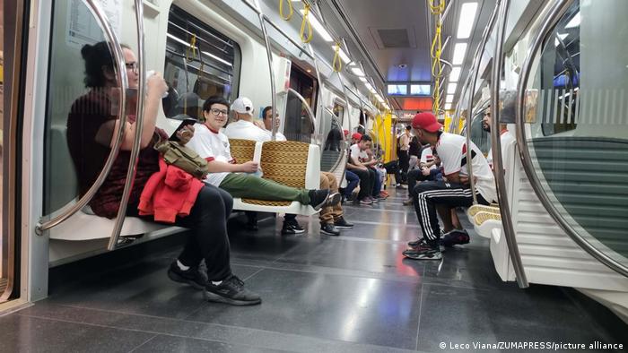 Mehrere Menschen, darunter Fans des FC São Paulo sitzen ohne Masken in einem U-Bahn-Wagon