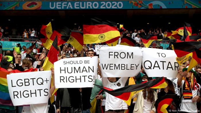 Fußball-Fans mit Deutschlandfahnen halten Schilder mit einer Botschaft zu den Menschenrechten in Katar hoch Fußball-Fans mit Deutschlandfahnen halten Schilder mit einer Botschaft zu den Menschenrechten in Katar hoch