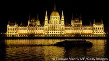 TOPSHOT - A boat passes on the Danube River in front of the Hungarian Parliament Building in Budapest on late December 13, 2021. (Photo by Ludovic MARIN / AFP) (Photo by LUDOVIC MARIN/AFP via Getty Images)