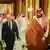Saudi Crown Prince Mohammed bin Salman gestures to Chancellor Olaf Scholz as they walk along a corridor in the Al-Salam Royal Palace in Jeddah, with several men walking behind them. September 24, 2022.