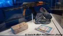 An AKM rifle that was found near the body of Usama Bin Laden during the raid on his compound in Abbottabad, Pakistan, is on display with a brick from the compound in the refurbished museum in the CIA headquarters building in Langley, Va., Saturday, Sept. 24, 2022. (AP Photo/Kevin Wolf)