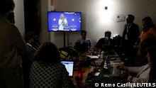 26.09.2022 Members of the media look at a television screen with Leader of Brothers of Italy Giorgia Meloni speaking, at the Democratic Party's election night headquarters, in Rome, Italy September 26, 2022. REUTERS/Remo Casilli