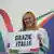 "Gracias italia", reza el cartel que sostiene una sonriente Giorgia Meloni.
