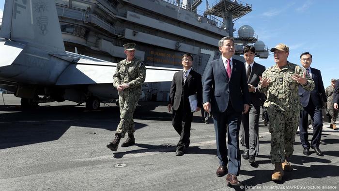 South Korea's defense minister with US military officials on the deck of the USS Ronald Reagan