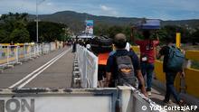 Venezuelan citizens walk through the international bridge between Colombia and Venezuela in San Antonio del Tachira, Venezuela, on September 25, 2022. - Venezuela and Colombia will open their land and air borders on September 26 after being partially closed in 2015 and completely closed in 2019 after the breaking of diplomatic relations between the two countries. (Photo by Yuri CORTEZ / AFP)