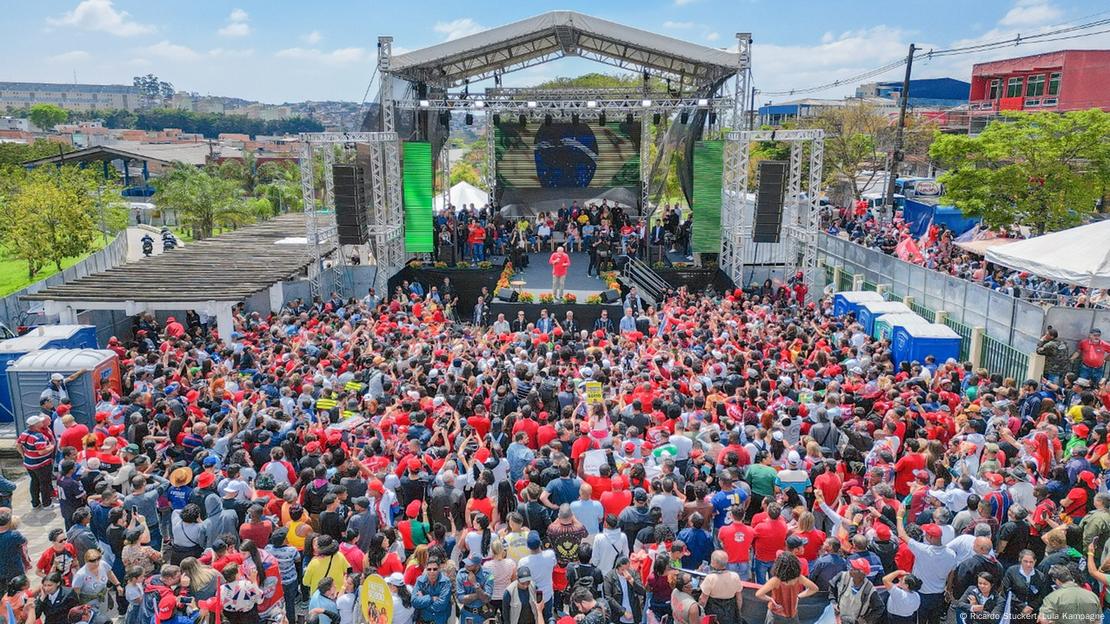 Vista aérea do comício de Lula, com aglomeração de pessoas em frente a palco, onde o petista discursa.