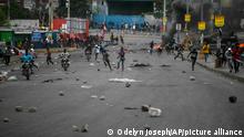 People run on the street following clashes in Haiti
