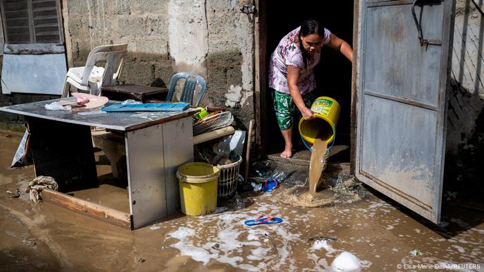 Foto de archivo de una persona que saca agua de su casa tras una inundación en Filipinas.