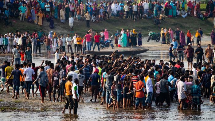 Dozens people on banks of a river, close to the town of Boda, in northern Bangladesh