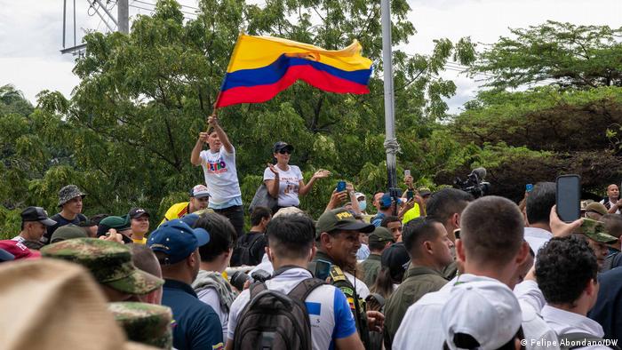 Manifestantes ondean una bandera colombiana al paso del presidente Gustavo Petro.