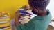 Criança escolhe livros em pilha Criança escolhe livros em pilha