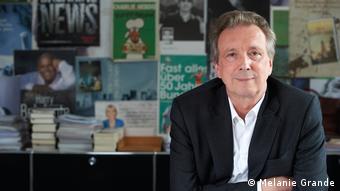 Helge Malchow, ehemaliger Verlagschef von Kiepenheuer & Witsch, sitzt in einem Sakko mit verschränkten Armen an einem Tisch.