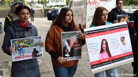 Drei iranische Frauen zeigen Protestplakate