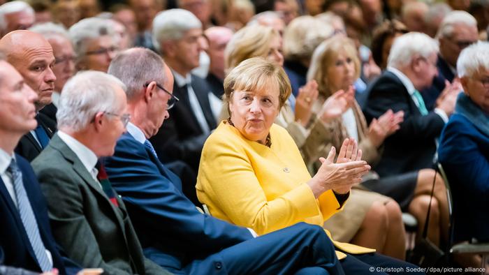Angela Merkel and Friedrich Merz in the crowd during the opening of the Chancellor Helmut Kohl foundation in Berlin, with Merkel visibly applauding -- September 27, 2022.