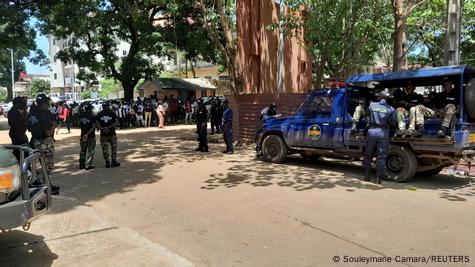 Des membres des forces de sécurité se tiennent dans une rue avant le procès de onze hommes accusés d'être responsables du massacre au stade de Conakry Des membres des forces de sécurité se tiennent dans une rue avant le procès de onze hommes accusés d'être responsables du massacre au stade de Conakry