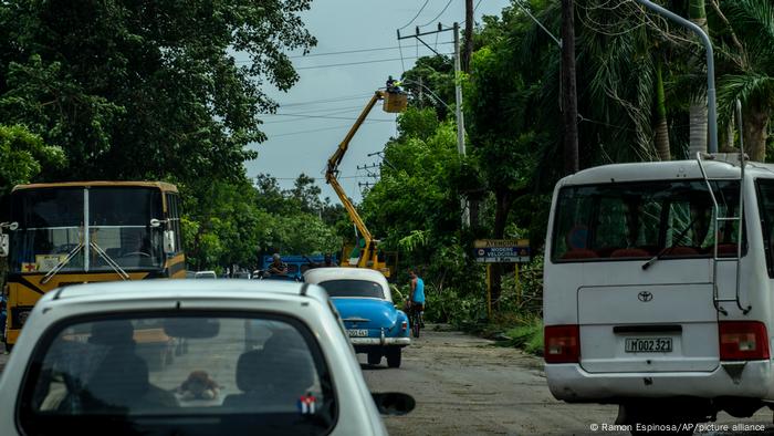 Un trabajador repara el tendido eléctrico subido a una grúa en una calle de la capital cubana.