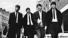 Black and white picture of four men dressed in smart suits identified as British popstars the Beatles