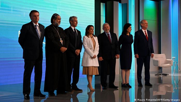 En la imagen se ve a Bolsonaro, padre Kelmon, Luiz Felipe D'Avila, Soraya Thronike, Lula, Sime Tebet y Ciro Gomes, candidatos a la presidencia de Brasil durante un debate.