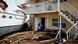 A man helps a woman next to a damaged boat amid a downtown condominium after Hurricane Ian caused widespread destruction, in Fort Myers, Florida, US, September 29, 2022. A man helps a woman next to a damaged boat amid a downtown condominium after Hurricane Ian caused widespread destruction, in Fort Myers, Florida, US, September 29, 2022.