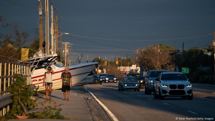 People walk the streets of Bomita Springs examining the damage. 