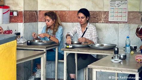 Duas mulheres comem em restaurante modesto
