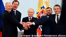 From left, Moscow-appointed head of Kherson Region Vladimir Saldo, Moscow-appointed head of Zaporizhzhia region Yevgeny Balitsky, Russian President Vladimir Putin, center, Denis Pushilin, leader of self-proclaimed of the Donetsk People's Republic and Leonid Pasechnik, leader of self-proclaimed Luhansk People's Republic pose for a photo during a ceremony to sign the treaties for four regions of Ukraine to join Russia, at the Kremlin in Moscow, Friday, Sept. 30, 2022. The signing of the treaties making the four regions part of Russia follows the completion of the Kremlin-orchestrated referendums. (Grigory Sysoyev, Sputnik, Kremlin Pool Photo via AP)