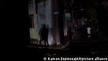 Residents walk through darkened streets after four days of power outages caused by Hurricane Ian, in Havana, Cuba, Friday, Sept. 30, 2022. (AP Photo/Ramon Espinosa)