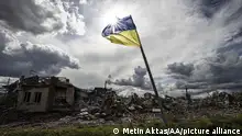 DOLINA, DONETSK, UKRAINE - SEPTEMBER 24: Ukrainian flag waves in a residential area heavily damaged in the village of Dolyna in Donetsk Oblast, Ukraine after the withdrawal of Russian troops on September 24, 2022. Many houses and St. George's Monastery were destroyed in the Russian attacks. Ukraine said on Saturday that its soldiers were entering the city of Lyman in the eastern region of Donetsk, which Russia had annexed a day earlier. Metin Aktas / Anadolu Agency