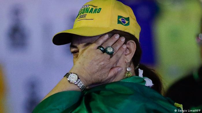 Un seguidor del presidente Jair Bolsonaro llora tras escuchar en Brasilia el resultado de la primera vuelta electoral.