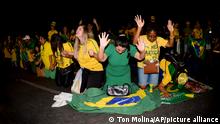 Supporters of Brazilian President Jair Bolsonaro, who is running for another term, pray as they listen to the partial results after general election polls closed in Brasilia, Brazil, Sunday, Oct. 2, 2022. (AP Photo/Ton Molina)