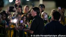 Brazilian President Jair Bolsonaro, who is running for another term, talks to followers after general election polls closed in Brasilia, Brazil, Sunday, Oct. 2, 2022. (AP Photo/Eraldo Peres)