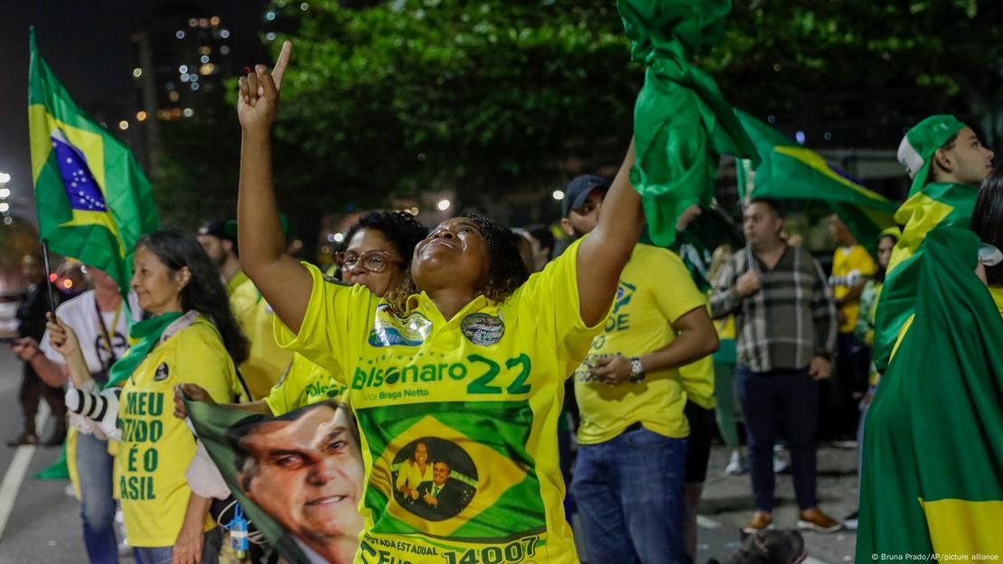 Apoiadores de Bolsonaro festejam na rua com bandeiras brasileiras e camisas verde-amarelo