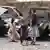 أطفال يمنيون أمام حطام سيارات في مدينة تعز في المين 04.05.2022