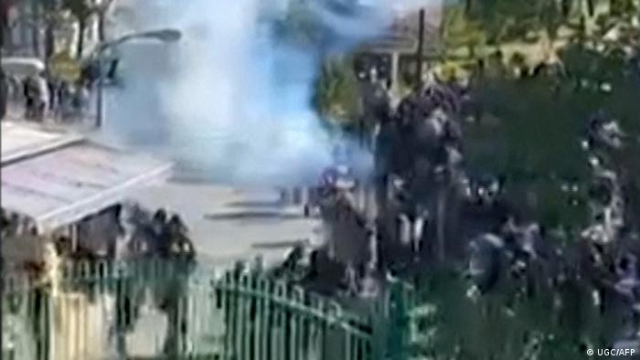 Blurred image of Iranian students fleeing tear gas near the entrance gate of Isfahan University.