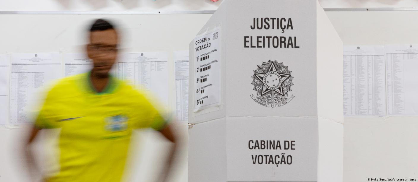 Homem com camisa da seleção brasileira sai de cabina de votação após votar