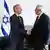 EU foreign policy chief Josep Borrell shakes hands with Israeli Intelligence Minister Elazar Stern in front of Israeli and EU flags