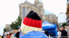 03.10.2022 *** Ein Besucher des Bürgerfestes zum Tag der Deutschen Einheit trägt auf dem Domplatz eine Mütze in den Farben Schwarz, Rot und Gold. In der Thüringer Landeshauptstadt finden die zentralen Feierlichkeiten zum Tag der Deutschen Einheit statt.